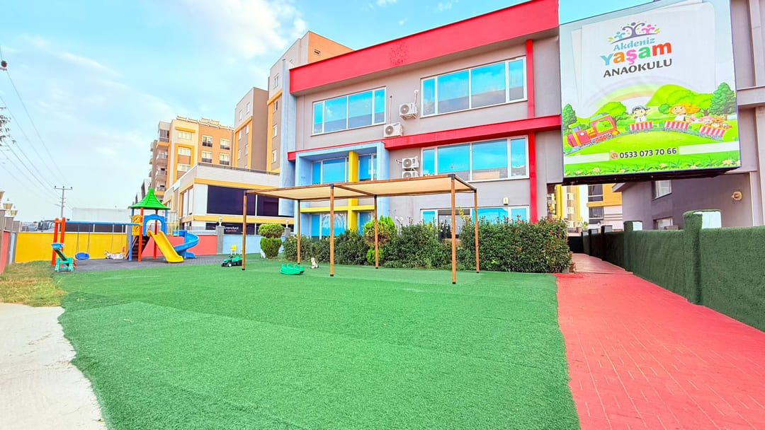 Çim kaplı kapalı oyun bahçesi ve oyun grubu